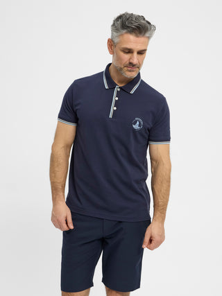 Navy kortærmet polo fra Redgreen i 100 % bomuld med kontraststribet krave og ærmekant samt lille sejlskibslogo.
